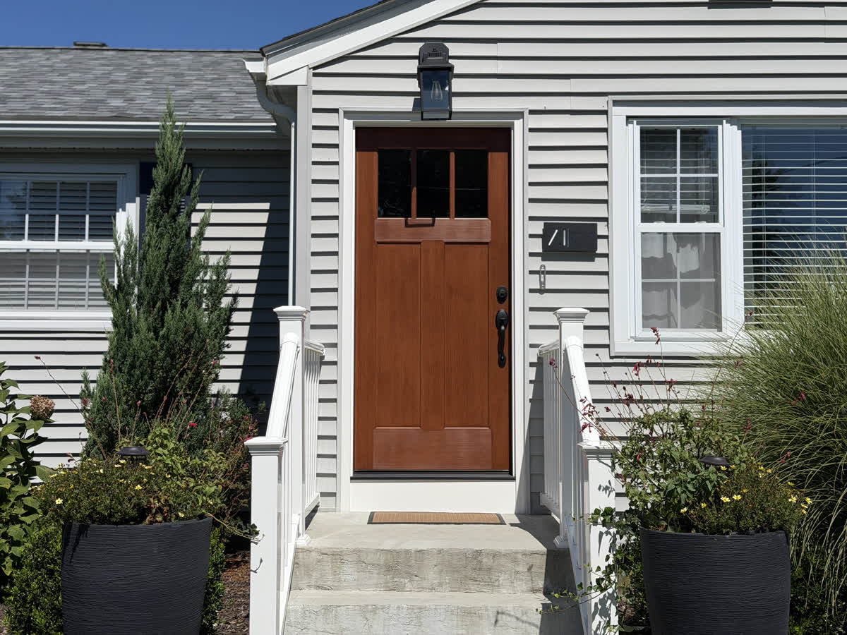 Finished front door installation on a shingled home
